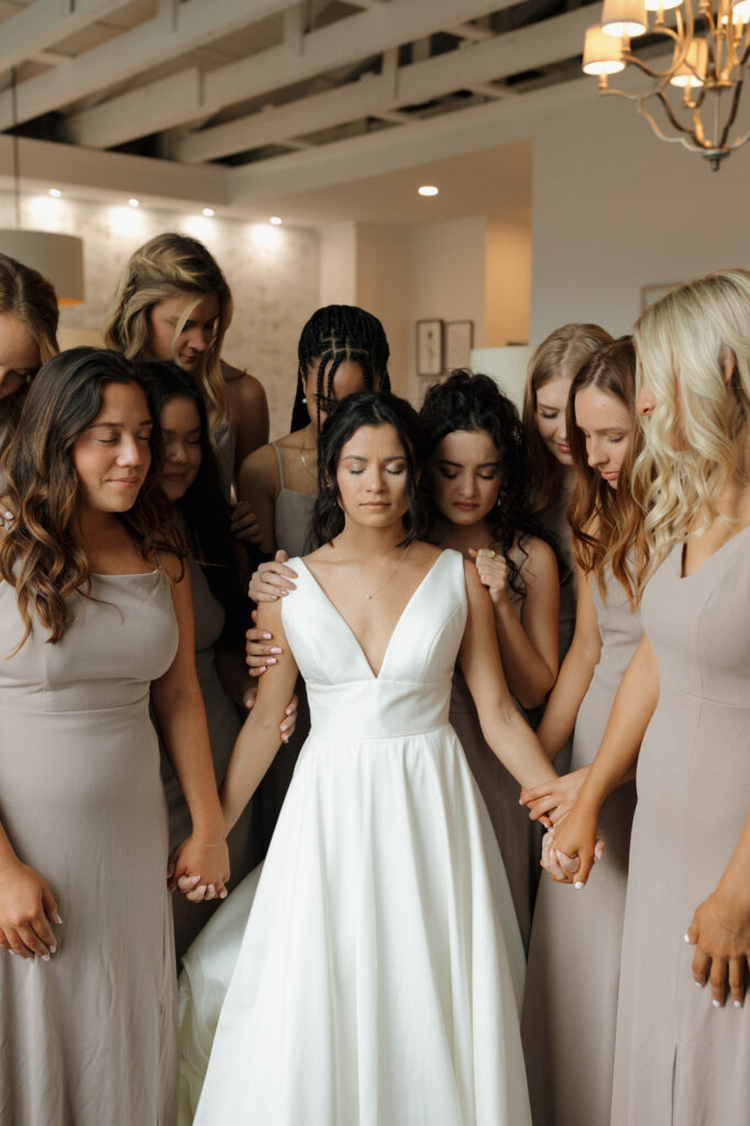 Bridesmaids praying over bride before the ceremony