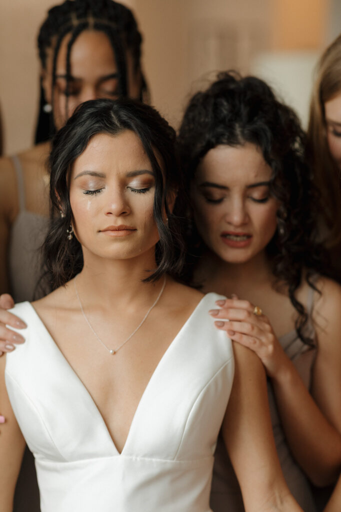 bridesmaids praying over bride at 5eleven palafox