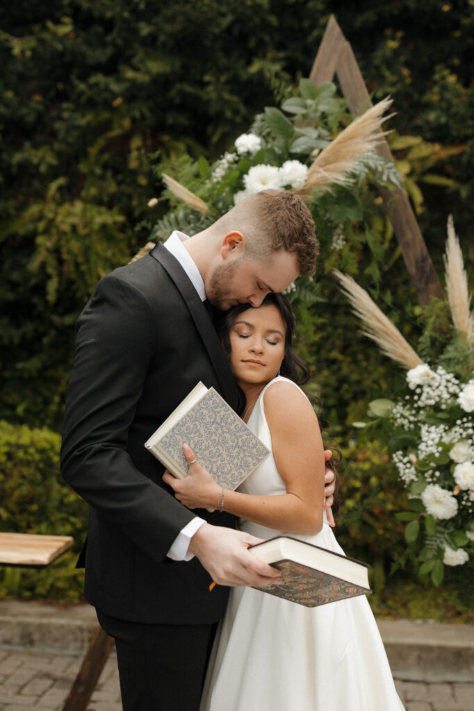 Bride and groom exchanging Bibles during first look at 5eleven Palafox