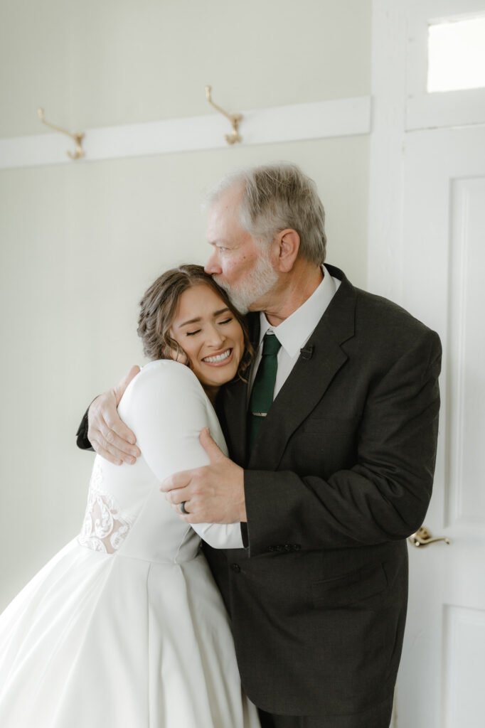 father of bride kissing bride before the ceremony