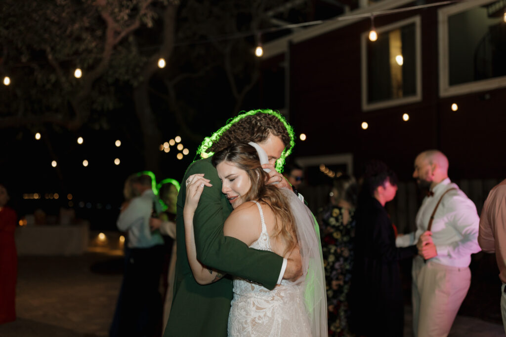 Grant and Mary hugging quietly at their wedding reception at bayfront lodge and cabin