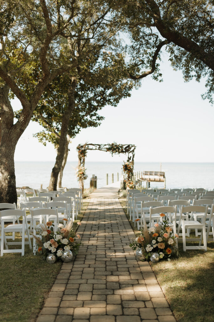 Moody ceremony beach location with florals at Florida waterfront wedding