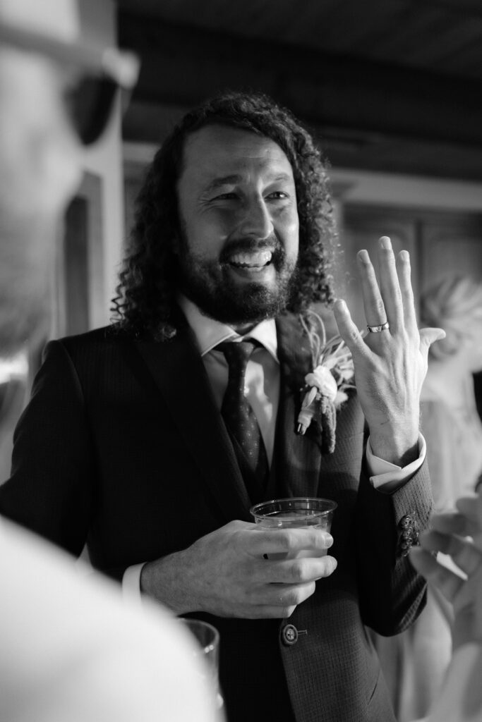 groom showing his wedding ring to guests at bayfront lodge and cabin