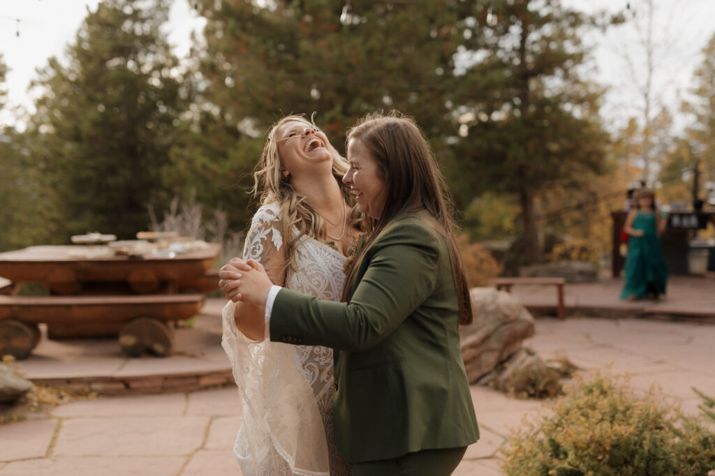 Brides dancing at outdoor wedding reception in the mountains