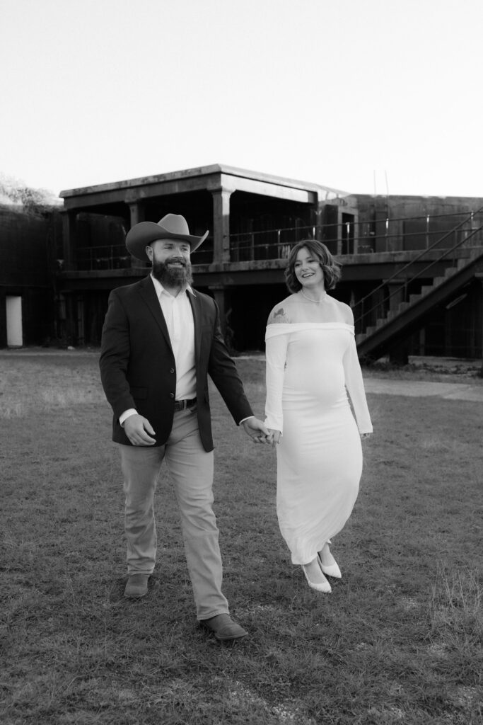 Candid photo of newlyweds laughing together during portraits at Fort Pickens after their elopement