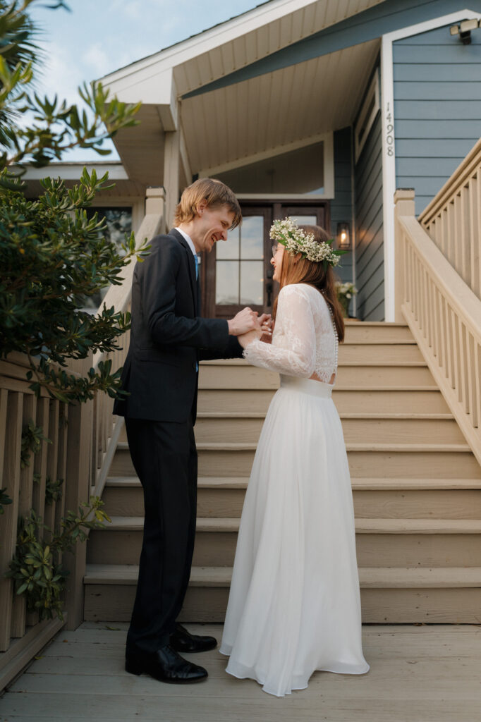 bride and groom having first look outside beach house before wedding in perdido key