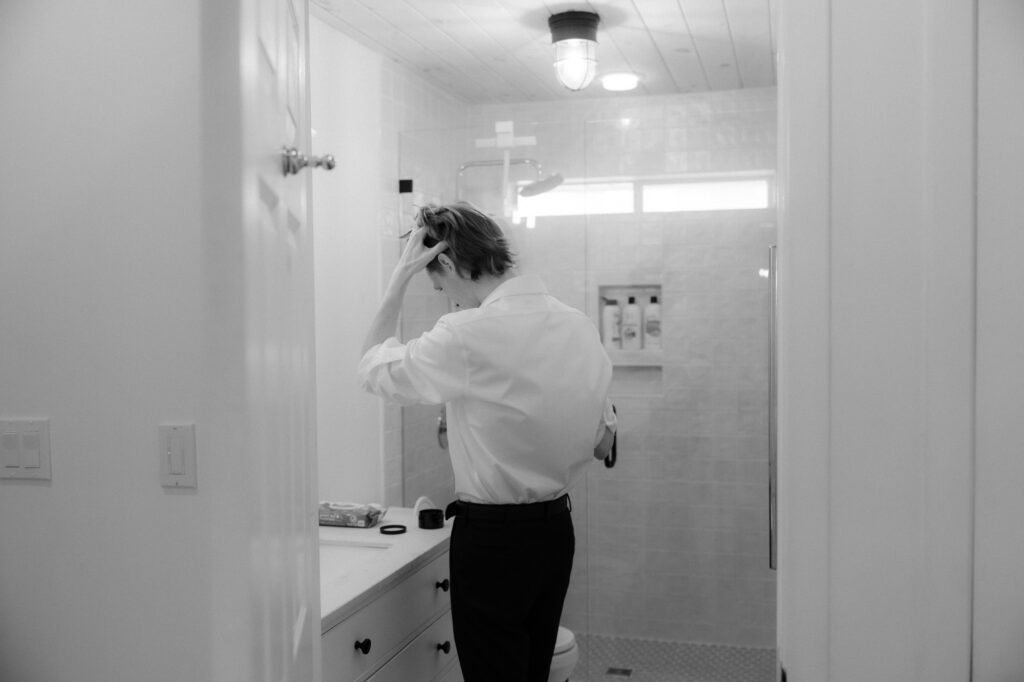 groom getting ready in beach house before wedding ceremony