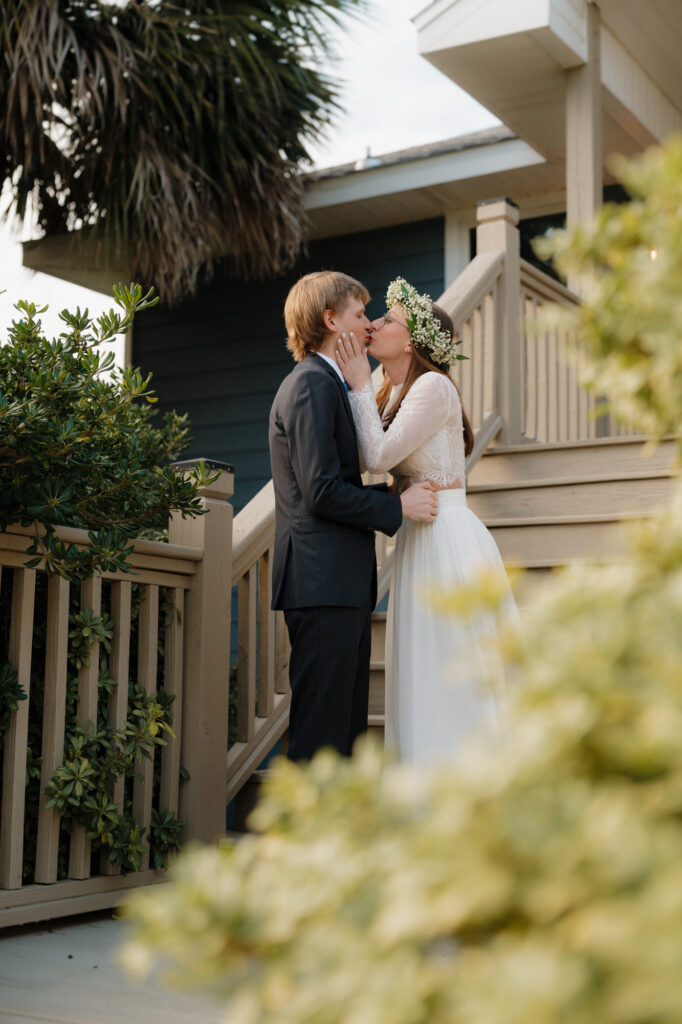 bride and groom kissing after first look at their beach house wedding venue in perdido key