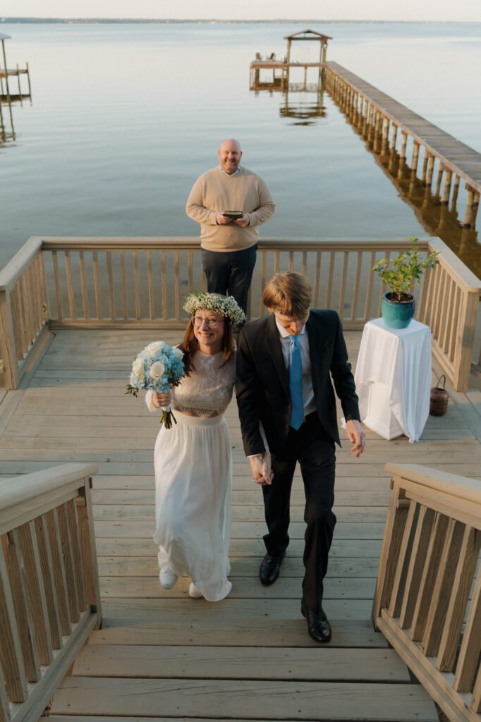 Bride and groom exchanging vows on a wooden dock during their intimate Perdido Key wedding ceremony