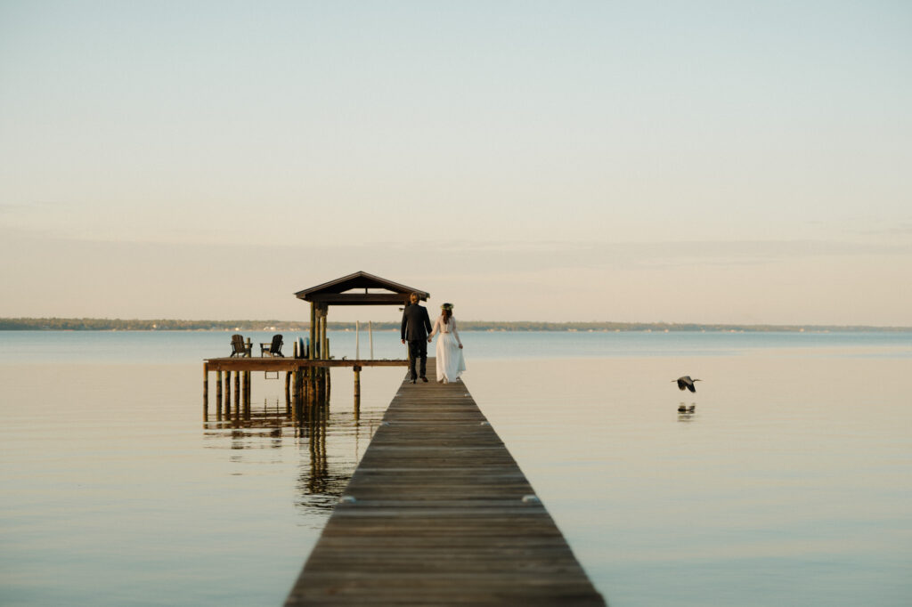 bride and groom walking on dock after ceremony in perdido key at a beach house